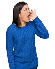 Wall Mural - Young hispanic woman wearing casual clothes shouting and screaming loud to side with hand on mouth. communication concept.