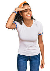young african american girl wearing casual clothes very happy and smiling looking far away with hand