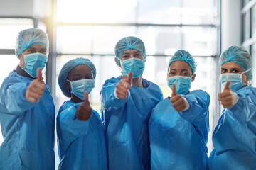 Fototapete - The surgery was a success. Portrait of a group of medical practitioners showing thumbs up in a hospital.