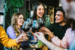 © Nicolas Micolani - Group of  friends clinking and cheers  red wine glasses sitting at table bar restaurant-Young people having fun and toasting wine together enjoying happy hour at winery pub-Lifestyle concept