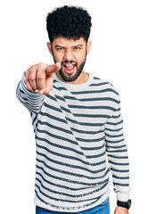 Wall Mural - Young arab man with beard wearing casual striped sweater pointing displeased and frustrated to the camera, angry and furious with you