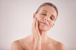 © Jeff B/peopleimages.com - Graceful beauty. Cropped studio shot of a beautiful mature woman touching her face.