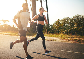 Poster - In the fitness game for the long run. Shot of a fit young couple going for a run outdoors.
