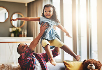 Poster - Next destination, fun. Shot of an adorable little girl and her father playing together on the sofa at home.