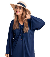 Poster - Middle age hispanic woman wearing summer hat smiling doing phone gesture with hand and fingers like talking on the telephone. communicating concepts.