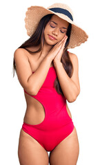 Sticker - Young beautiful latin girl wearing swimwear and summer hat sleeping tired dreaming and posing with hands together while smiling with closed eyes.