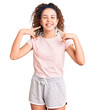 © Krakenimages.com - Beautiful kid girl with curly hair wearing casual clothes smiling cheerful showing and pointing with fingers teeth and mouth. dental health concept.