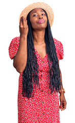 Canvas Print - Young african american woman wearing summer hat doing italian gesture with hand and fingers confident expression