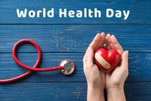Hands Holding Red Heart And Stethoscope On Wooden Background. World Health Day