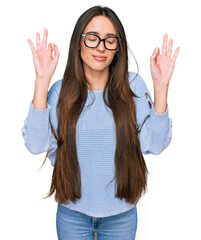 Sticker - Young hispanic girl wearing casual clothes and glasses relax and smiling with eyes closed doing meditation gesture with fingers. yoga concept.