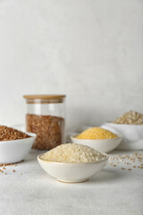 Wall Mural - Bowl with rice and different cereals on light background