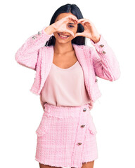 Sticker - Young beautiful latin girl wearing business clothes doing heart shape with hand and fingers smiling looking through sign