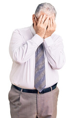 Canvas Print - Senior grey-haired man wearing business clothes with sad expression covering face with hands while crying. depression concept.