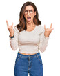 © Krakenimages.com - Young brunette woman wearing casual clothes and glasses shouting with crazy expression doing rock symbol with hands up. music star. heavy concept.