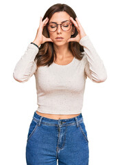 Canvas Print - Young brunette woman wearing casual clothes and glasses with hand on head for pain in head because stress. suffering migraine.