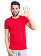 © Krakenimages.com - Young handsome man with beard wearing casual t-shirt showing and pointing up with fingers number five while smiling confident and happy.