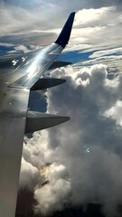 exceptionally beautiful jet airplane window view of clouds reflected in aircraft wing. generic trave