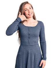 Sticker - Young beautiful blonde woman wearing casual dress smiling doing phone gesture with hand and fingers like talking on the telephone. communicating concepts.