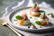 Delicious pink and white somen canapes with salted plum and prosciutto ham on a white platter 