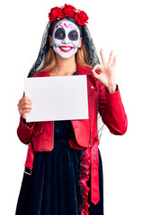 Sticker - Woman wearing day of the dead costume holding blank empty banner doing ok sign with fingers, smiling friendly gesturing excellent symbol