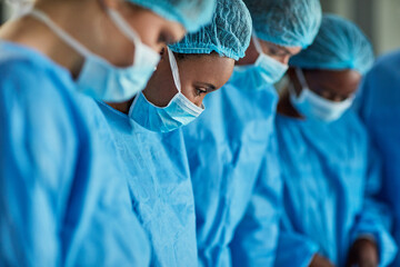 Sticker - Focused in the operating theatre. Cropped shot of a group of surgeons performing a medical procedure in an operating room.