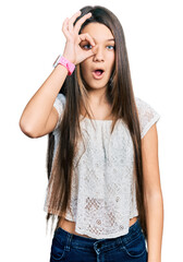 Poster - Young brunette girl with long hair wearing white shirt doing ok gesture shocked with surprised face, eye looking through fingers. unbelieving expression.