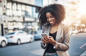 Aufkleber - I love it when I receive texts with good news. Shot of a young businesswoman using a cellphone in the city.