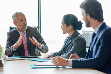Poster - Leading them through his vision. Shot of a group of executives having a meeting in a boardroom.