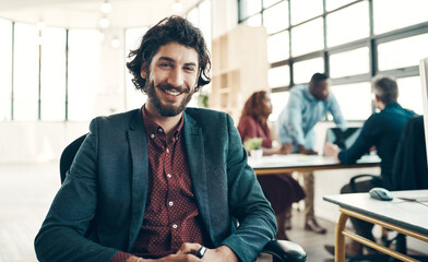 Aufkleber - Greet every workday with a positive attitude. Portrait of a young businessman sitting in a modern office with his colleagues working in the background.