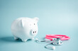 Piggy bank with stethoscope. money health check concept. Health care financial checkup and saving for medical insurance cost planning in the future.