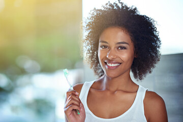 Canvas Print - Working for that winning smile. Cropped portrait of a young woman brushing her teeth in the bathroom.