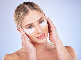 Wall Mural - Face portrait, skincare and woman with eye mask in studio isolated on a blue background. Dermatology, makeup cosmetics and beauty of female model with facial patches for healthy skin or collagen.