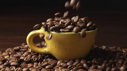 Wall Mural - Coffee beans pouring fly slow motion in cup.hot drink roasted bean coffee.
slow motion falling Coffee .