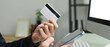 © Prathankarnpap - Man holding credit cad and using mobile phone smartphone for online banking transaction or entering data for website form