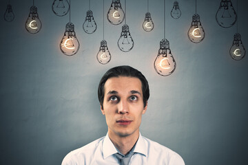 Poster - Thoughtful young european businessman standing on concrete wall background with glowing lamp sketches and euro sign. Business ideas, income and success concept.