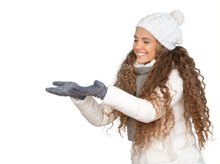 Wall Mural - Young Woman In Winter Clothes With Hands Out Against Falling Snow - Isolated