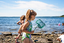 Girl On Coastline With Fishing Net, Bristol, Rhode Island, USA