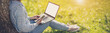 © candy1812 - Woman with laptop sitting on the grass in the natural park.