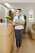 © DragonImages - Positive luxurious spa salon manager standing at reception