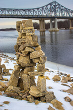 Rock Stacking On Rivers Edge By Bridge