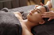 © DragonImages - Young Asian woman getting face massage in spa salon