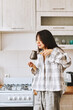 © olga pink - Tasty flavor. Morning begins with fresh coffee. Asian woman sniffs freshly brewed coffee in cevze