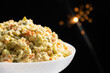 Olivier russian salad - a classic recipe with mayonnaise, an incredible taste, on a black background, with bokeh of sparklers for christmas and new year