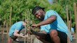 African American men volunteer helpers planting trees in mangrove forest for environmental protection and ecology, reduce global warming