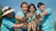 Group of Asian volunteer showing hands soiled in mud sign smiling look at camera helpers planting trees in mangrove forest for environmental protection and ecology, reduce global warming