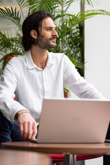 Wall Mural - portrait d'un jeune homme employé de bureau ou homme d'affaires qui travaille sur un ordinateur portable, assis dans un bureau confortable