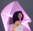 © Rethea B/peopleimages.com - Neon background, woman and beauty portrait in studio with purple ultraviolet light for makeup and fashion. Aesthetic gen z model black person with hologram for natural cosmetics, art uv glow abstract