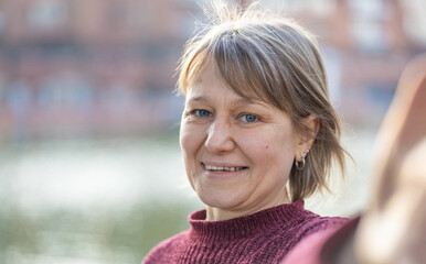 Happy smiling senior woman taking selfie outdoors . Mature caucasian female takes a photo looking at the camera