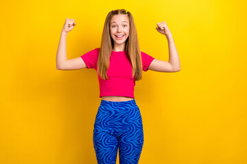 Poster - Portrait of nice cute satisfied girl with long hairdo dressed pink top arms demonstrate biceps isolated on yellow color background