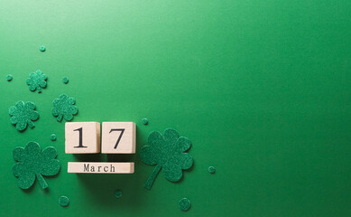 Wall Mural - Happy St Patrick's Day decoration concept made from shamrocks ( clover leaf), wooden calendar and leprechaun hat on green background.